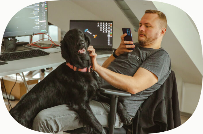 Inbanker taking a photo of an office dogs sitting on their lap