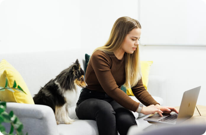 One of Inbankers working on the laptop with a cute office dog at their side